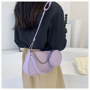 Détail du sac hobo lilas avec chaîne argentée et mini pochette porté par un modèle