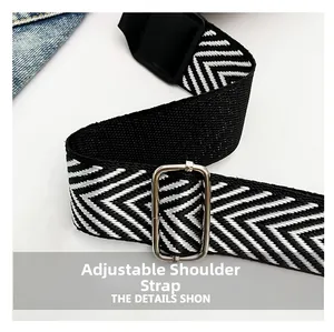 Detail of adjustable black and white herringbone woven strap with silver metal buckle