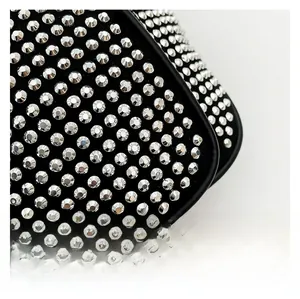 Macro detail of dense silver rhinestone inlay on fashionable black shoulder bag