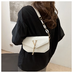 Detail of white leather shoulder bag with golden V-logo, fringe tassel and chain strap