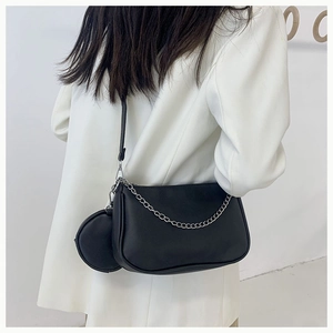 Gros plan du sac lune en cuir noir avec chaîne argentée et petite pochette ronde