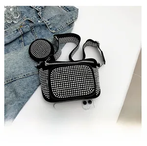 Detail of studded black crossbody bag with matching round coin purse and patterned strap
