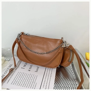 Détail du sac demi-lune marron caramel avec chaîne argentée et petit porte-monnaie rond