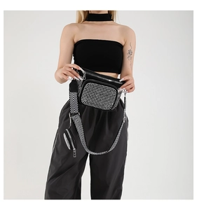 Détail du sac bandoulière noir avec strass argentés et large sangle à motifs