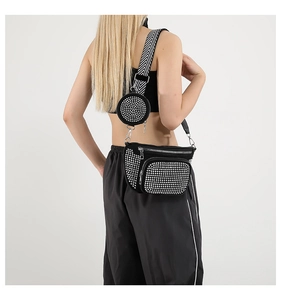 Detailed view of black rhinestone camera bag with wide herringbone crossbody strap