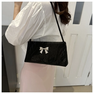 Minimalist black shoulder bag with silver metallic bow and textured crinkle finish