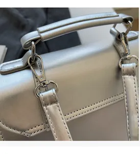 Detail of silver metallic PU bag showing high-quality polished hardware and fine stitching