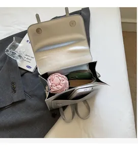 Macro view of silver metallic bag interior showing capacity for phone and umbrella