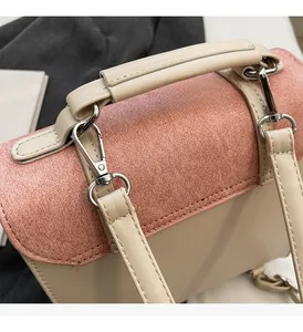 Detailed close-up of glossy pink texture and silver metal buckle on a dual-tone handbag