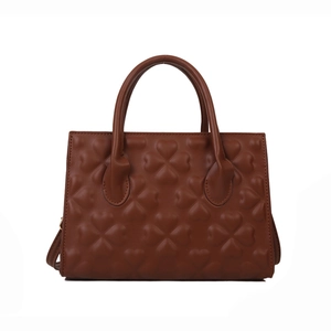 Brown handbag with lucky clover heart embossing, trapezoid shape and dual handles