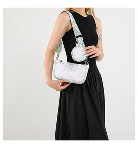 Détail du sac bandoulière blanc avec motif papillon vert et large sangle tissée