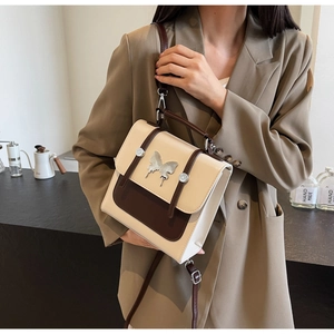 Retro contrast color crossbody bag with silver butterfly buckle shown in home setting