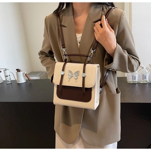 Detail of the butterfly metal clasp and contrast stitching on this vintage crossbody bag