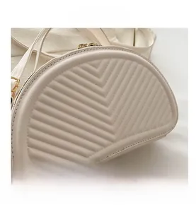Detailed close-up of cream white PU leather bag with V-shaped quilted texture