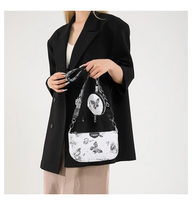 Vue détaillée du sac bandoulière blanc avec imprimés papillon et large sangle