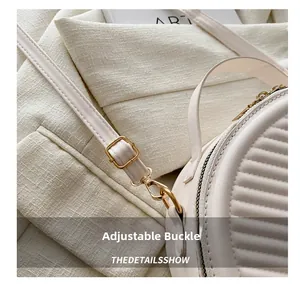 Detail of adjustable golden buckle on off-white quilted semi-circle handbag strap