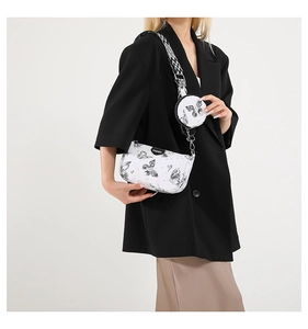 Détail du sac bandoulière avec imprimé papillon et large sangle géométrique ajustable