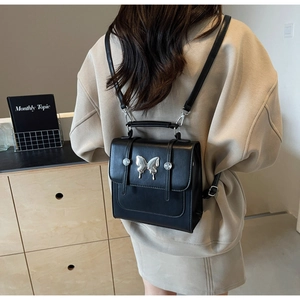 Versatile black PU leather small backpack with silver butterfly accent for women