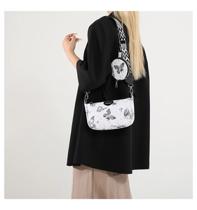 Détail du sac bandoulière blanc à motif papillon avec large sangle géométrique sur modèle