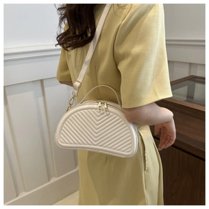 Detail of white saddle bag showing elegant V-quilted texture and gold hardware zipper