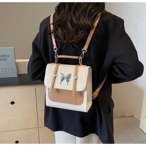 Detail view of the contrast color bag with silver butterfly and double strap design