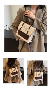 Detail of versatile contrast color square bag with metal butterfly buckle and leather strap