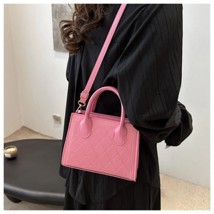 Dettaglio borsa trapuntata rosa con borchie a cuore dorate e tracolla regolabile rimovibile