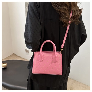 Détail du sac à main matelassé rose avec clous en cœur dorés et bandoulière réglable