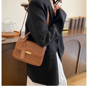 Chic brown flap crossbody bag with gold buckle and adjustable strap in lifestyle setting