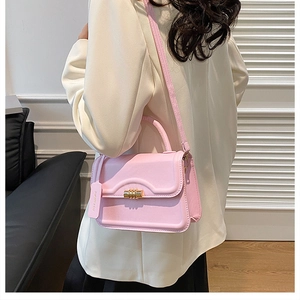 Pink PU leather crossbody square bag with gold lock shown in a stylish lifestyle scene