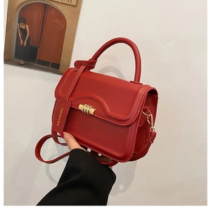 Close-up of red leather handbag showing gold twist lock and Fashion & Bag tag