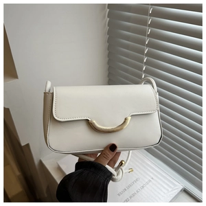 Détail du sac bandoulière en cuir blanc avec fermoir en métal doré minimaliste