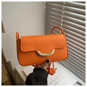 Vue détaillée du sac bandoulière orange avec boucle dorée et bandoulière nouée