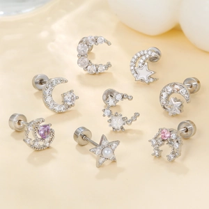 Silver celestial earring set with moon and star zircon studs on a textured background