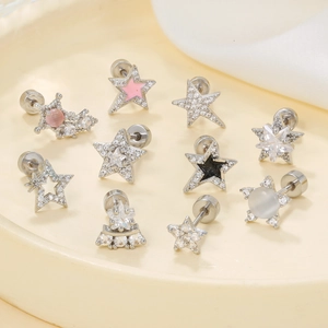 Star and moon themed stud earring set with zircons and enamel in a beige tray