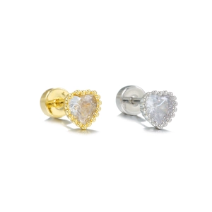 Macro shot of heart-shaped zircon earrings with milgrain edges in gold and silver finish