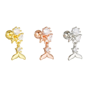 Détail de boucles d'oreilles queue de poisson en or, or rose et argent avec zircons et étoiles