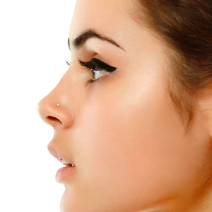 Minimalist gold nose stud with a clear diamond crystal worn on model side profile