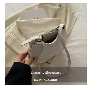 Interior detail showing white crescent bag capacity with smartphone and zipper