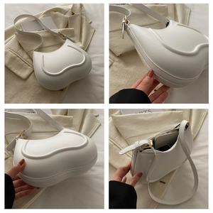 Detailed views of a white heart-shaped leather shoulder bag with gold hardware accents