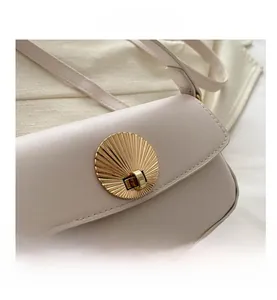 Close-up of the elegant golden shell-shaped metal lock and premium textured faux leather