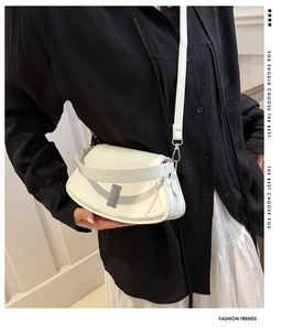 Detailed view of a white fan-shaped crossbody bag featuring elegant gold metal buckles