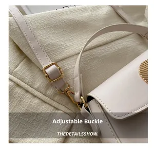Detail of cream PU leather shoulder bag with adjustable golden buckle and hardware