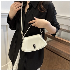 Detailed side view of white glossy leather fan-shaped handbag with silver metal hardware