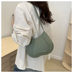 Hobo style moss green shoulder bag in matte leather shown with minimalist outfit