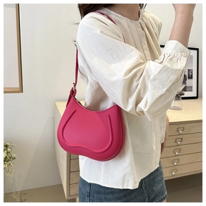 Detailed macro view of the wavy textured magenta leather crescent shoulder bag for women