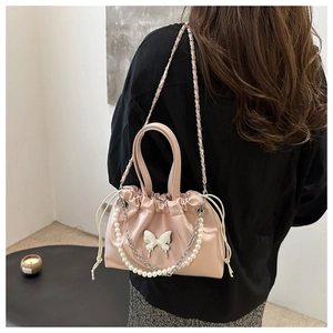 Sac seau rose avec breloque papillon argentée et élégante bandoulière en perles