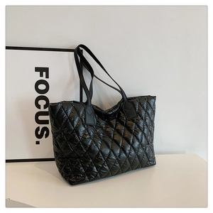 Minimalist black quilted tote bag with shiny finish and diamond stitch pattern