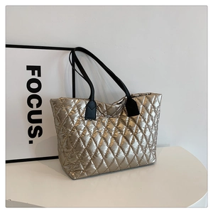 Close-up of champagne gold quilted tote bag with focus on puffy diamond stitching texture