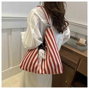 Detail view of red and white striped canvas tote with white lace ribbon side accents